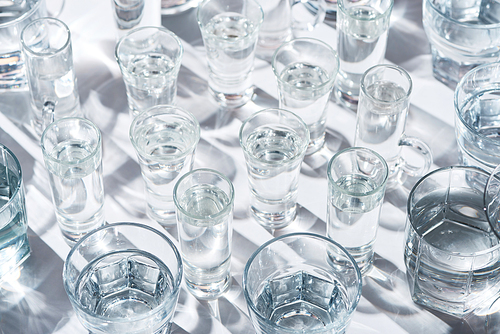 close up view of transparent glasses with water on white background