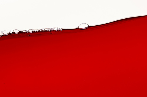 red bright liquid with bubbles on surface isolated on white