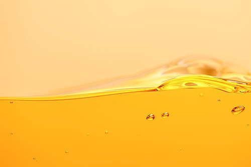 wavy yellow bright liquid with splash and bubbles isolated on yellow