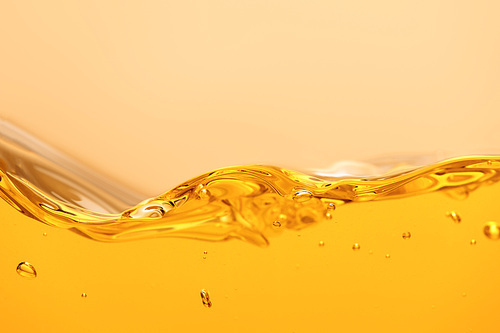 curved yellow bright liquid with splash and bubbles isolated on yellow