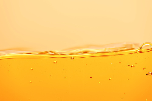 ripple yellow bright liquid with splash and bubbles isolated on yellow