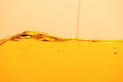 pouring yellow bright liquid with bubbles isolated on yellow
