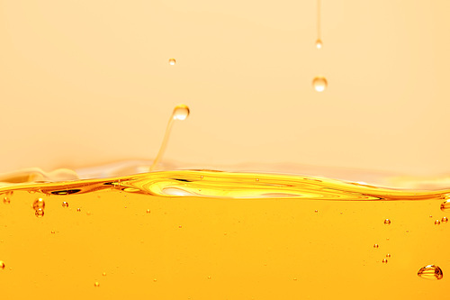 yellow bright liquid with drops and bubbles isolated on yellow