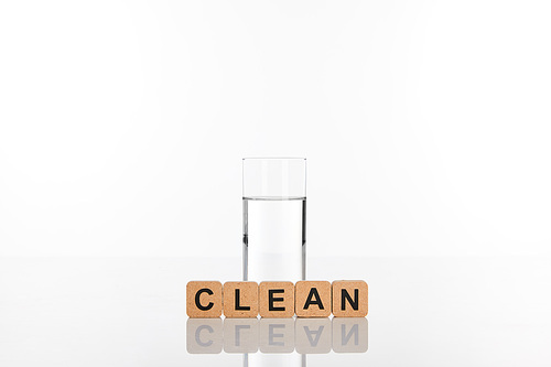 clear fresh water in glass near cubes with clean lettering isolated on white