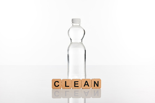 clear fresh water in bottle near cubes with clean lettering isolated on white