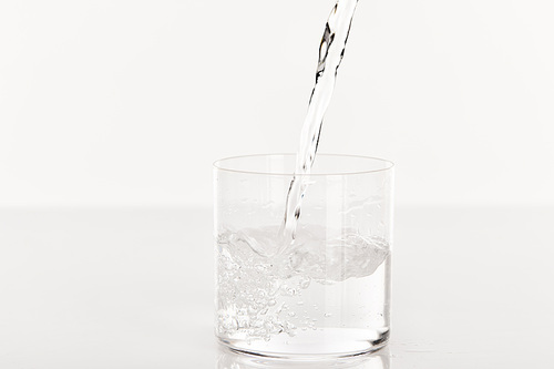 clear fresh water pouring into glass isolated on white