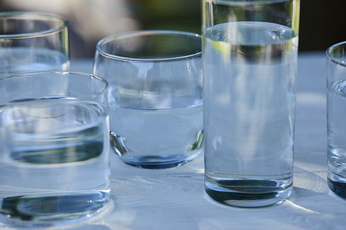 clear fresh water in transparent glasses on wooden table