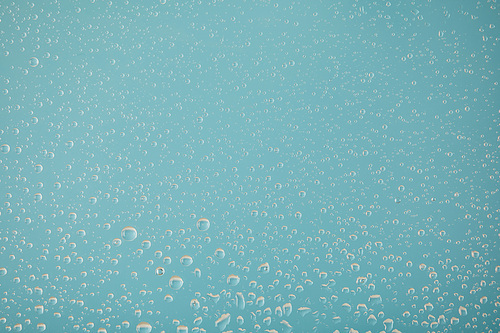 clear transparent water drops on light blue background