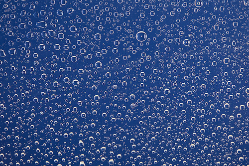 clear transparent water drops on blue background