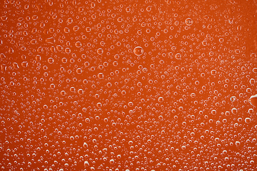 clear transparent water drops on orange background