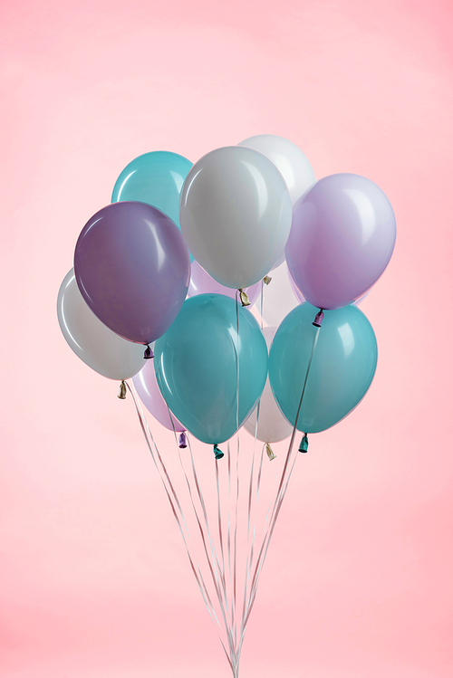 white, blue and purple party festive balloons on pink background