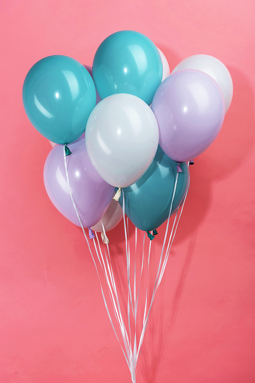colorful white, blue and purple decorative festive balloons on pink background