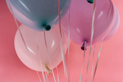 close up view of decorative purple, blue and white balloons on pink background