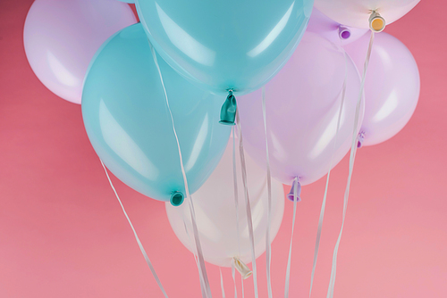 blue, white and purple festive balloons on pink background