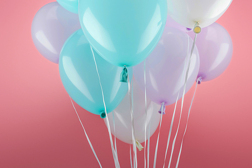 blue, white and purple decorative balloons on pink background