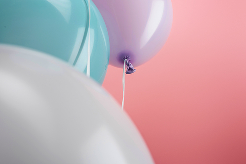 close up view of decorative colorful balloons on pink background