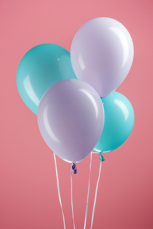 blue and purple colorful festive balloons on pink background