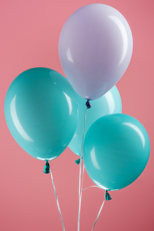 blue and purple colorful decorative festive balloons on pink background