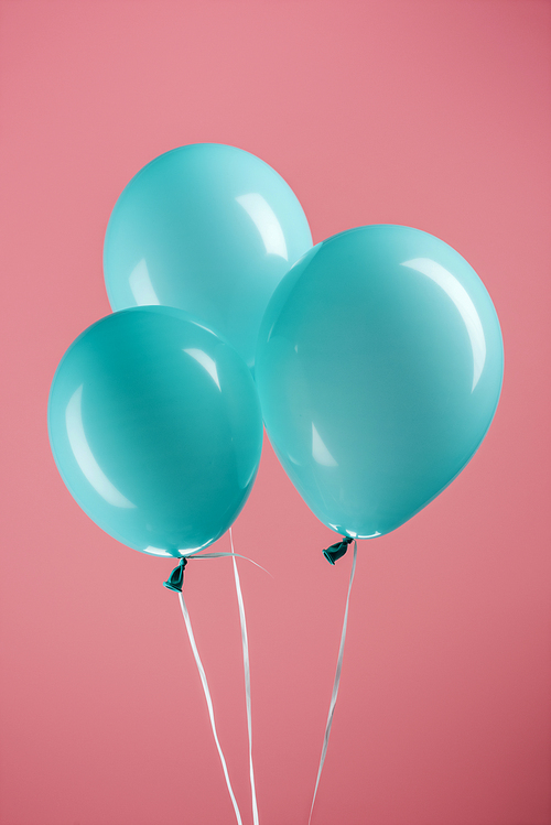 bright blue decorative festive balloons on pink background