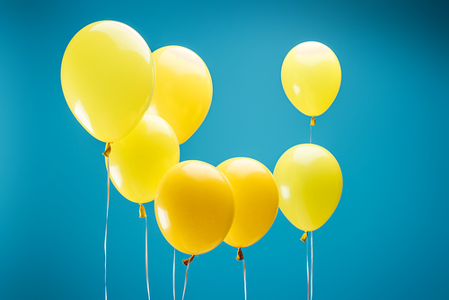 bright yellow festive balloons on blue background