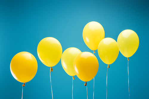 bright party yellow balloons on blue background