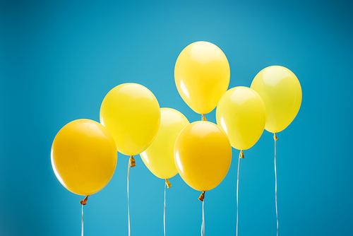 bright colorful yellow balloons on blue background