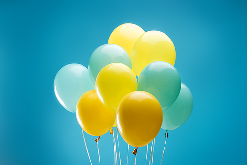 bright colorful yellow and blue balloons on blue background