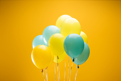festive decorative blue and yellow balloons on yellow background