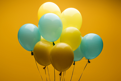 bright decorative blue and yellow balloons on yellow background