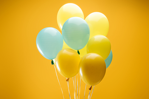 festive blue and yellow balloons on yellow background