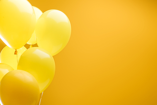 festive bright minimalistic decorative balloons on yellow background with copy space
