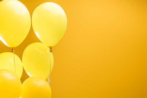festive minimalistic decorative balloons on yellow background with copy space