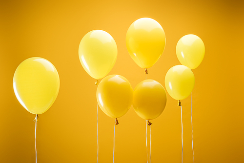 festive bright minimalistic decorative balloons on yellow background