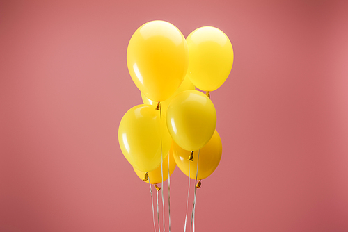 yellow bright festive balloons on pink background