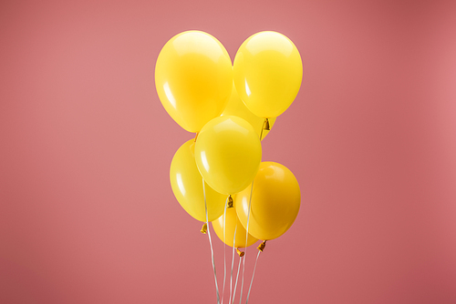 yellow bright balloons on pink background, party decoration