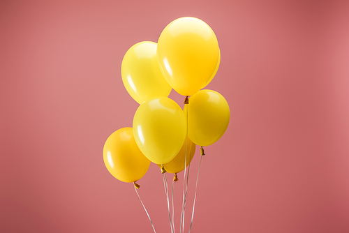 yellow bright festive balloons on pink background, party decoration