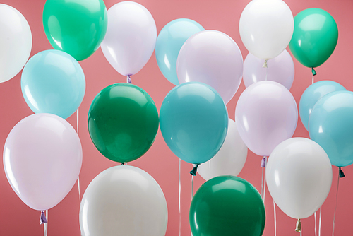 bright green, white and blue party decorative balloons on pink background