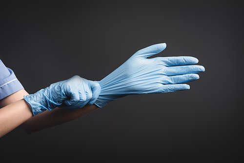 cropped view of nurse wearing latex gloves isolated on dark grey