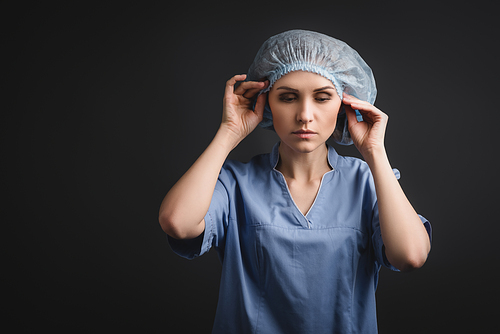 nurse wearing blue medical cap isolated on dark grey