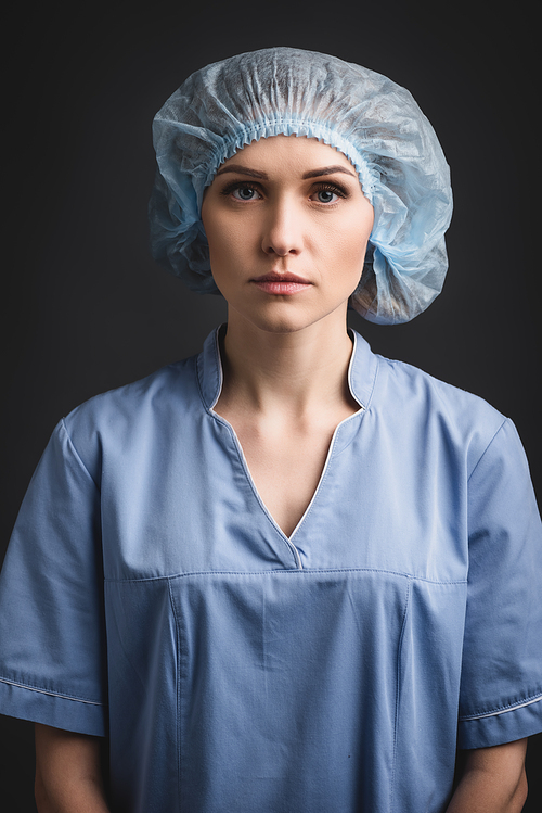 nurse in blue medical cap  isolated on dark grey