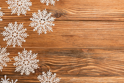 top view of winter snowflakes on wooden background