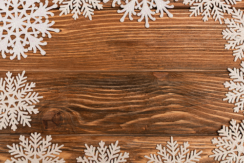 top view of winter snowflakes on wooden background
