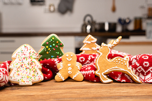 winter gingerbread cookies and scarf on wooden background