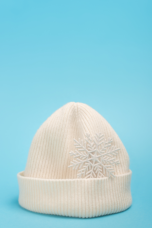 white beanie and snowflake on blue background