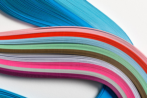close up of wavy multicolored rainbow paper lines on grey background