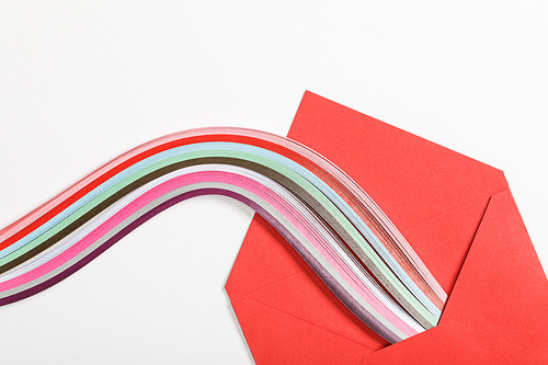 close up of red envelope with multicolored rainbow on white background