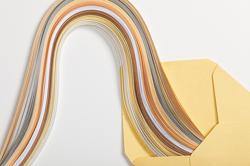 close up of yellow envelope with multicolored rainbow on grey background