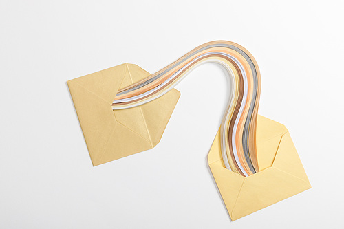 top view of yellow envelopes with multicolored rainbow on grey background