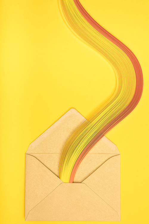 top view of open yellow envelope with rainbow on yellow background