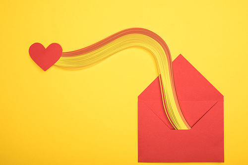 top view of open red envelope with  and heart sign on yellow background